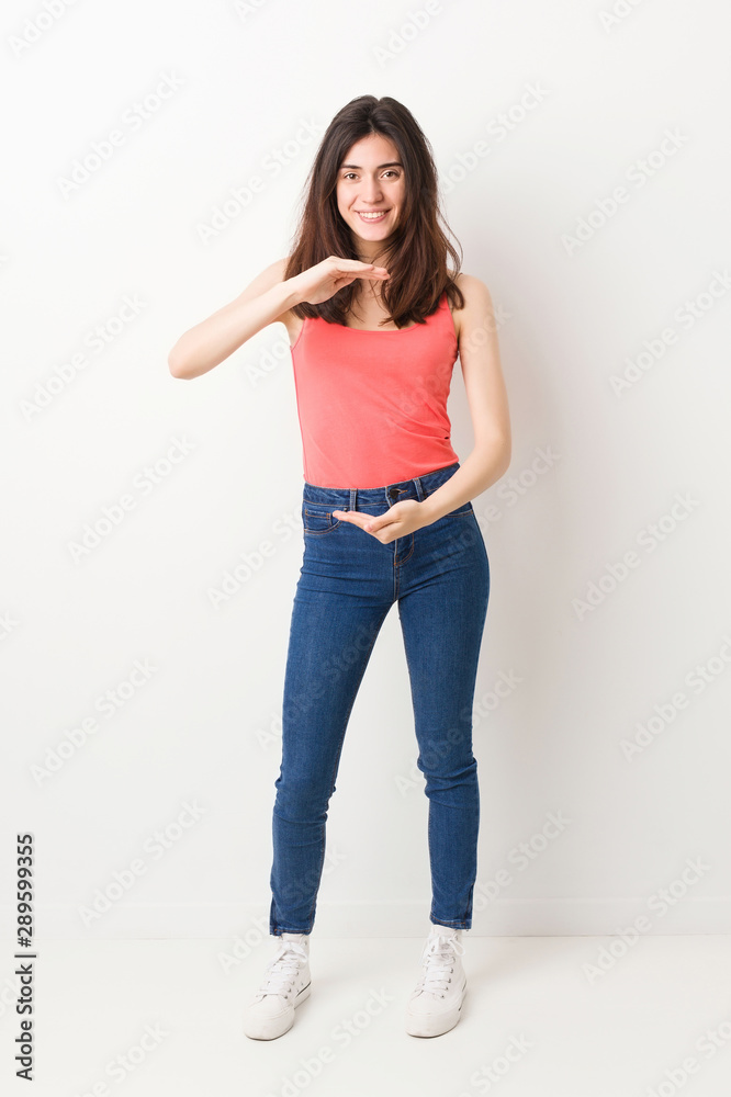 Full body young woman on white background holding something with both hands, product presentation.