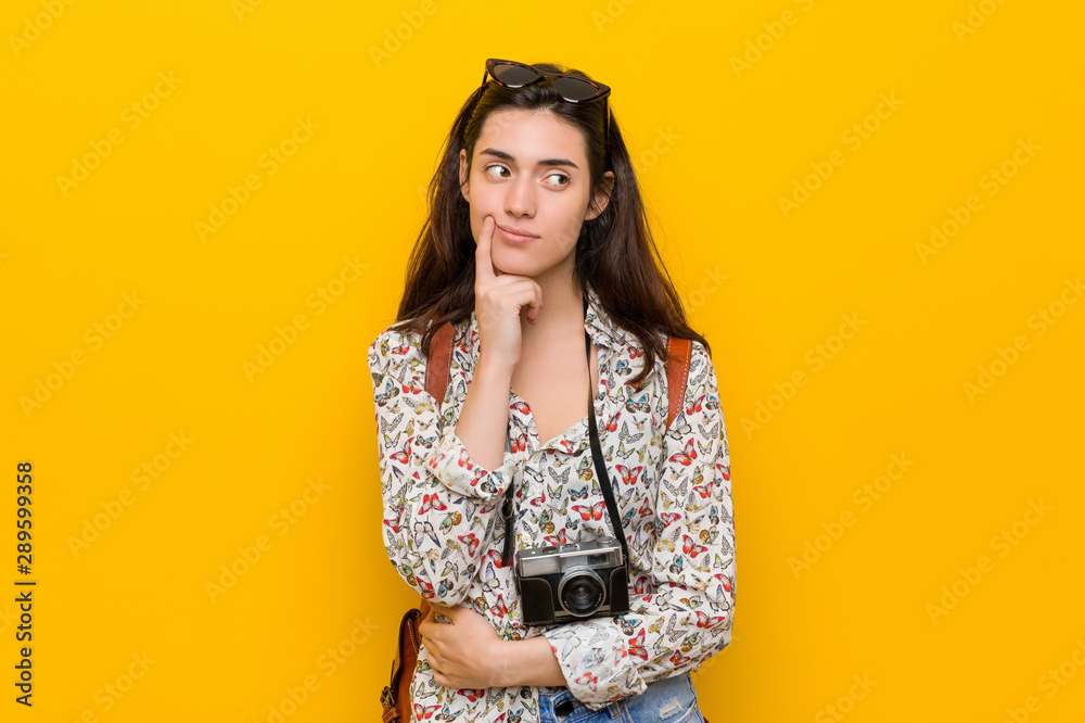 Young brunette traveler woman looking sideways with doubtful and skeptical expression. Young brunette traveler woman looking sideways with doubtful and skeptical expression.