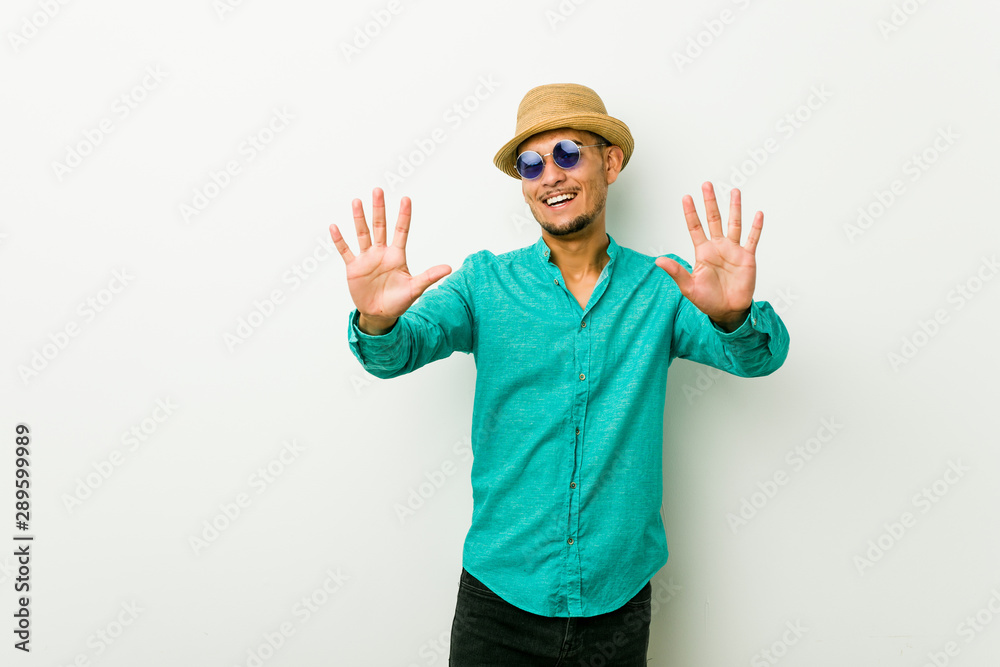 Young hispanic man wearing a summer clothes showing number ten with hands. Young hispanic man wearing a summer clothes showing number ten with hands.