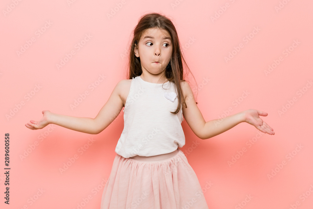 Little girl wearing a princess look shrugs shoulders and open eyes confused. Little girl wearing a princess look shrugs shoulders and open eyes confused.