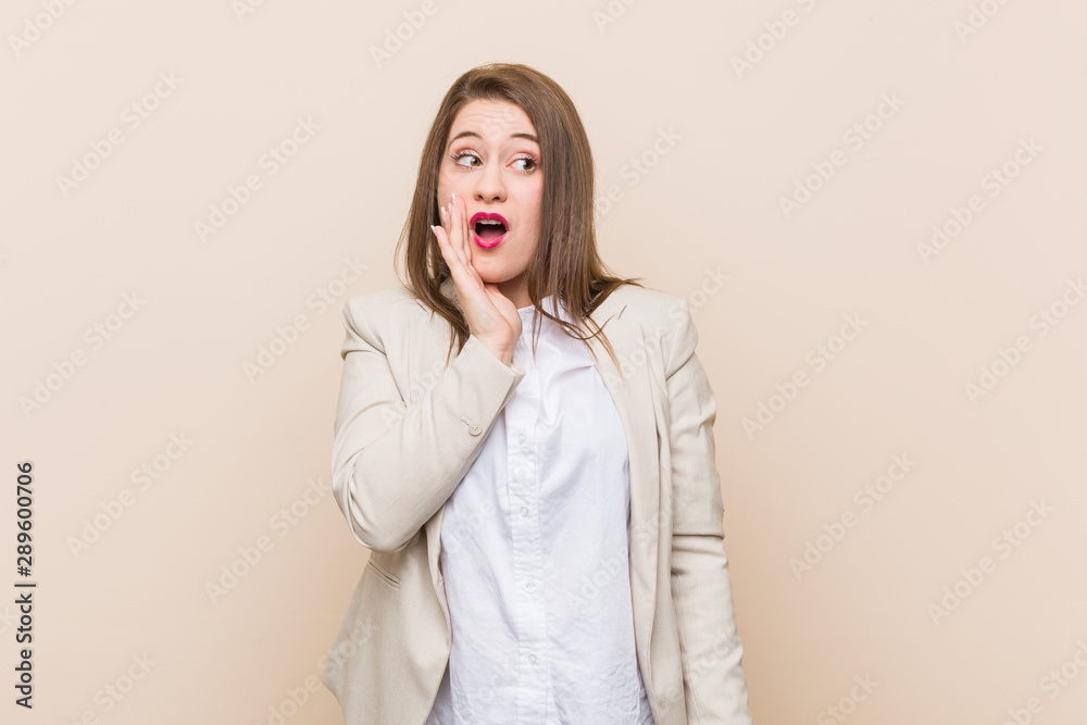Young business woman is saying a secret hot braking news and looking aside Young business woman is saying a secret hot braking news and looking aside