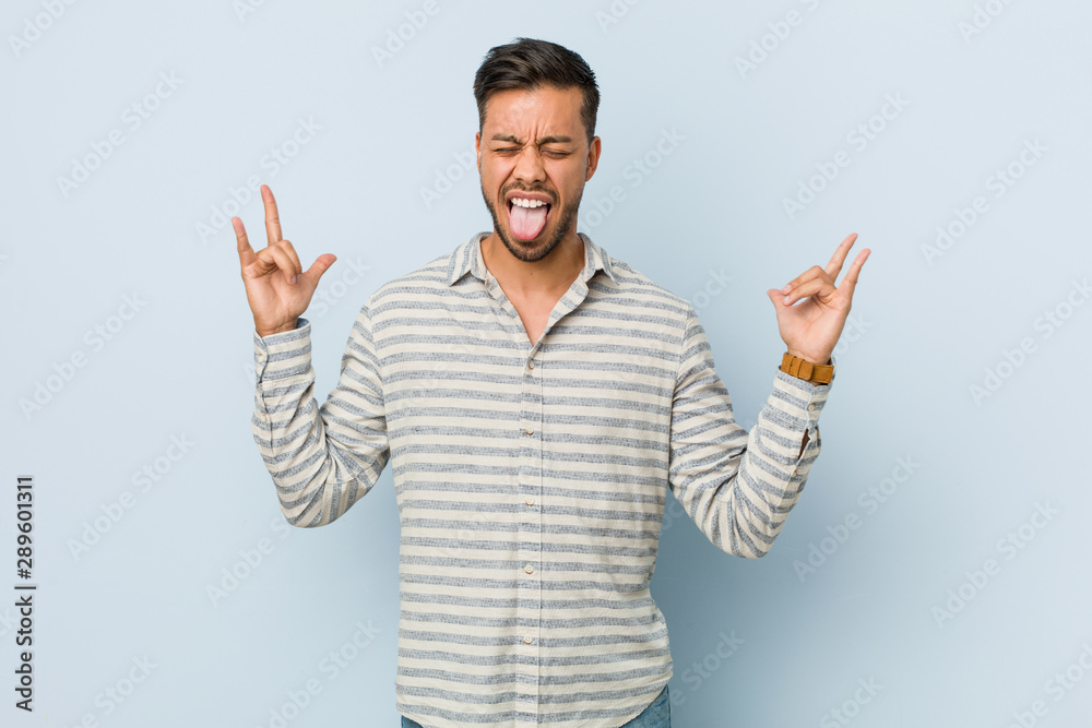 Young handsome filipino man showing rock gesture with fingers Young handsome filipino man showing rock gesture with fingers