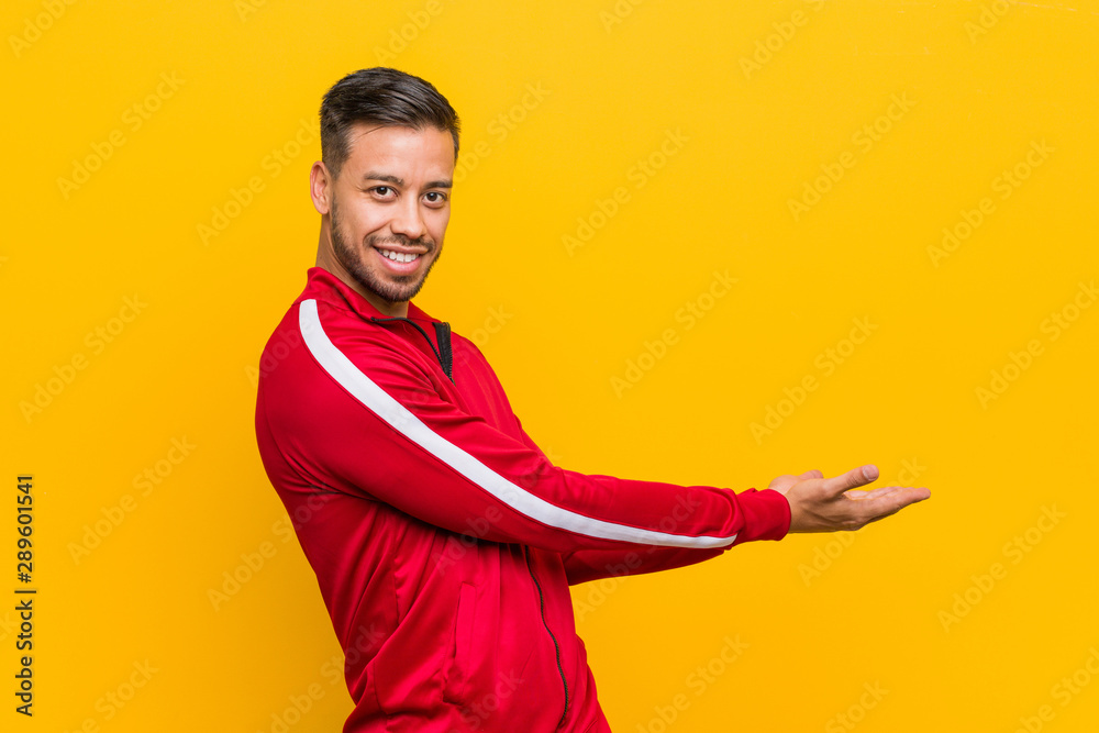 Young filipino fitness man holding a copy space on a palm. Young filipino fitness man holding a copy space on a palm.