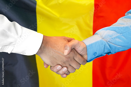 Business handshake on Belgium flag background. Men shaking hands and Belgium flag on background. Support concept