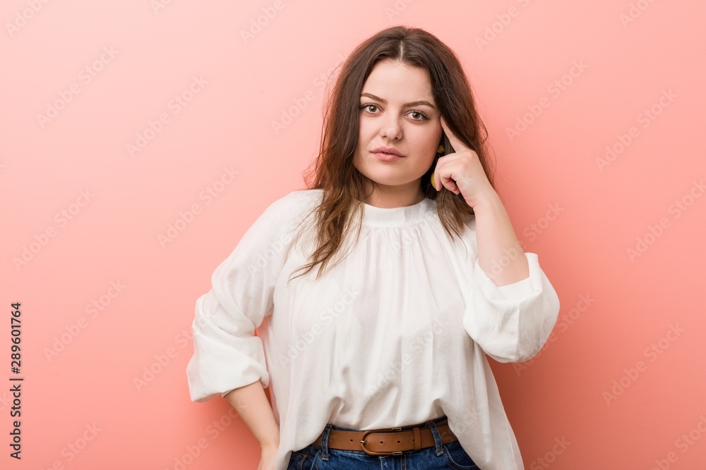 Young caucasian curvy woman standing against pink background Young caucasian curvy woman standing against pink background