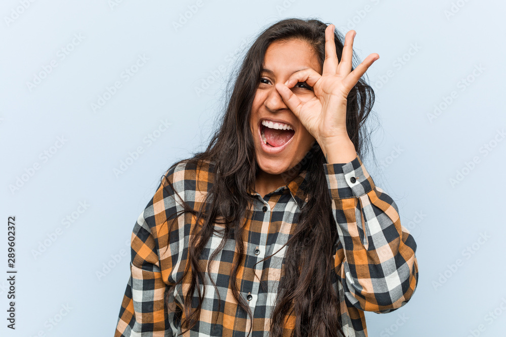 Young cool indian woman excited keeping ok gesture on eye. Young cool indian woman excited keeping ok gesture on eye.