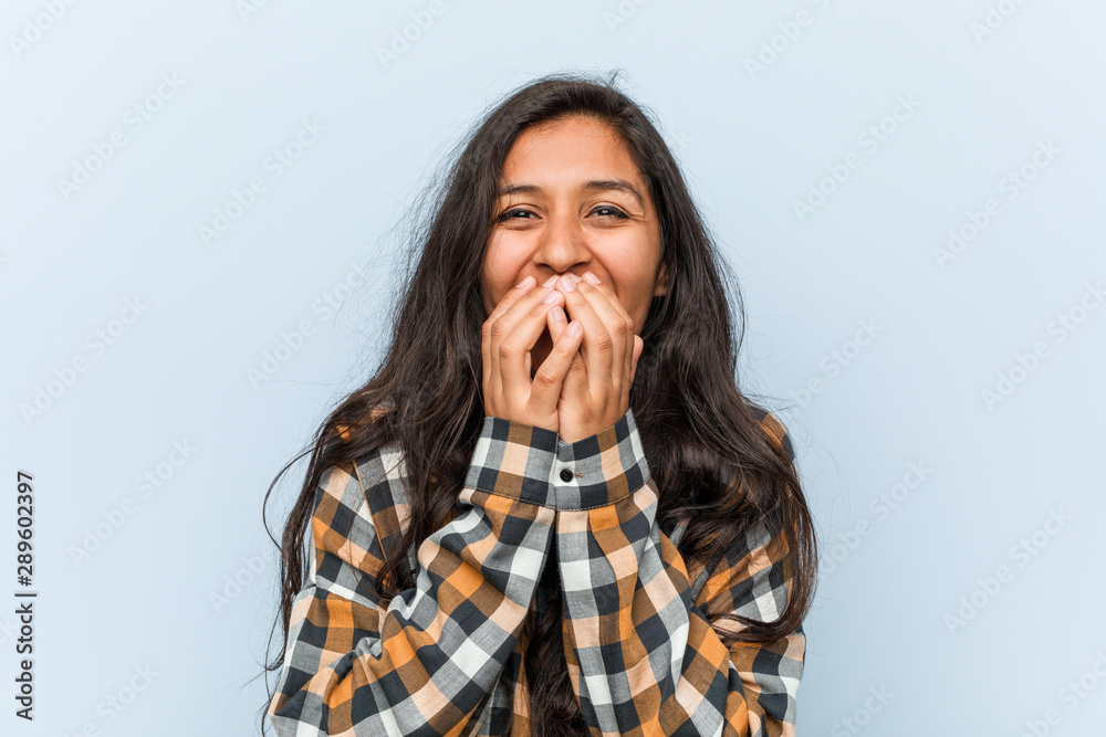 Young cool indian woman laughing about something, covering mouth with hands. Young cool indian woman laughing about something, covering mouth with hands.