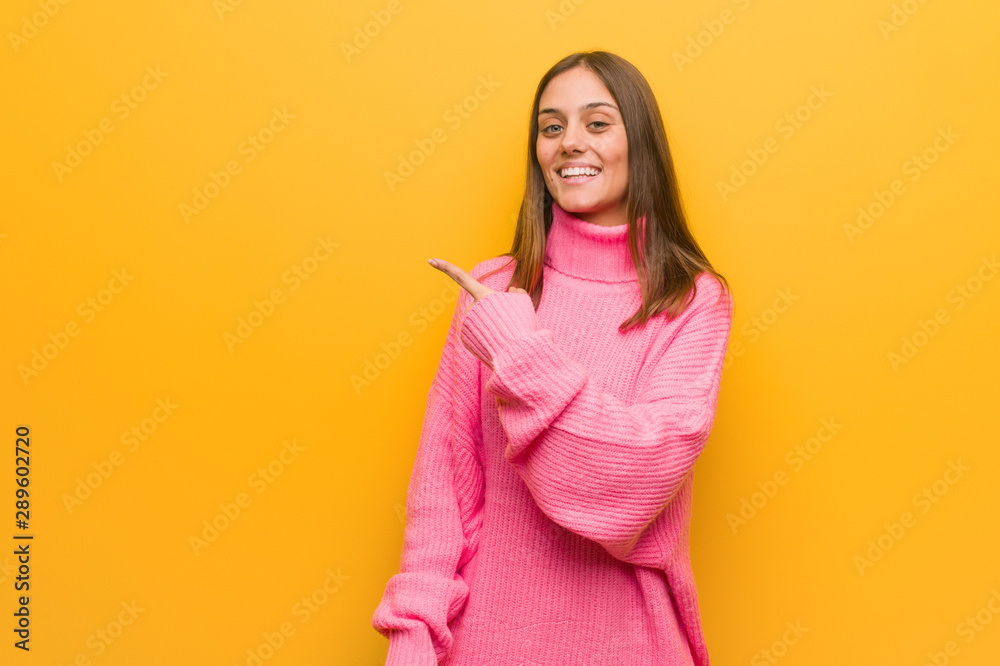 Young modern woman smiling and pointing to the side Young modern woman smiling and pointing to the side