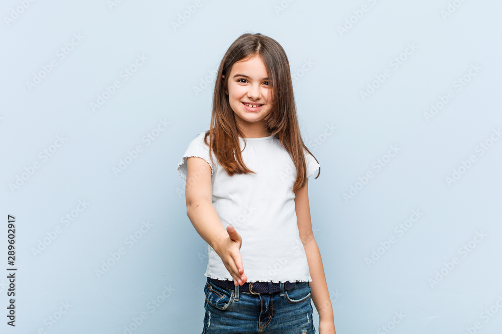 Cute girl stretching hand at camera in greeting gesture. Cute girl stretching hand at camera in greeting gesture.