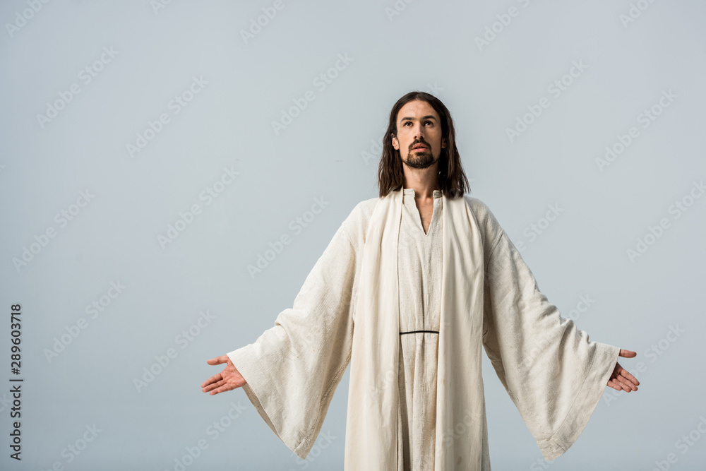 handsome man with belief standing with outstretched hands isolated on grey