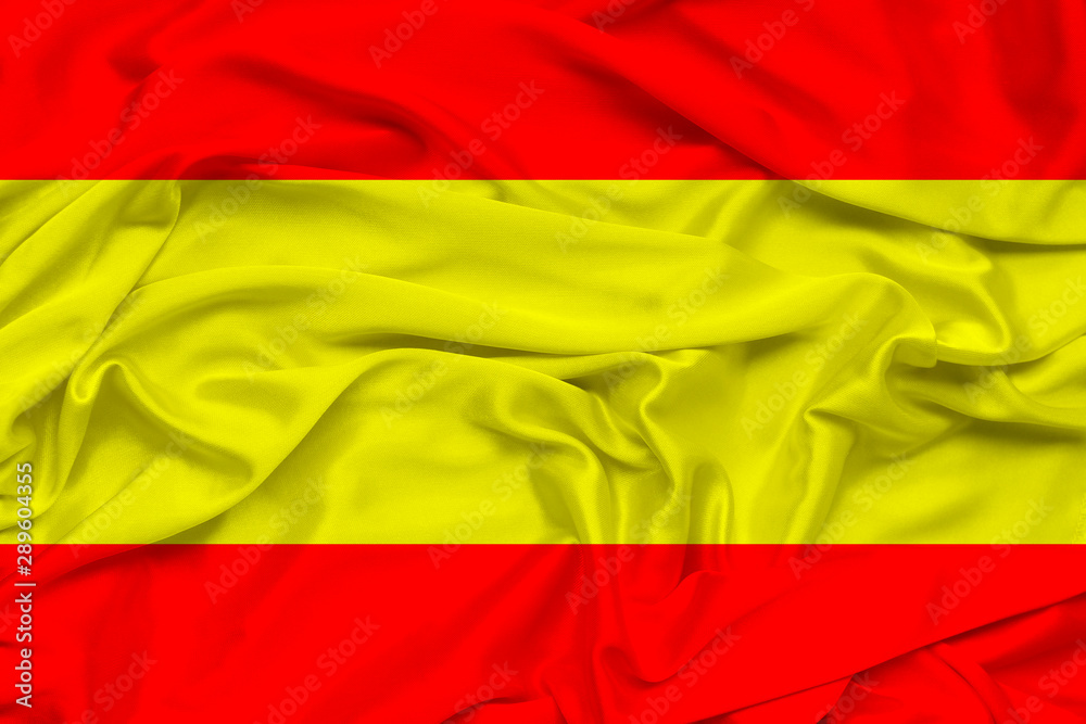 beautiful photo of the national flag of Spain on delicate shiny silk with soft draperies, the concept of the country's national life, horizontal, closeup, copy space
