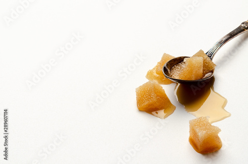 melted sugar cube on white background on the spoon