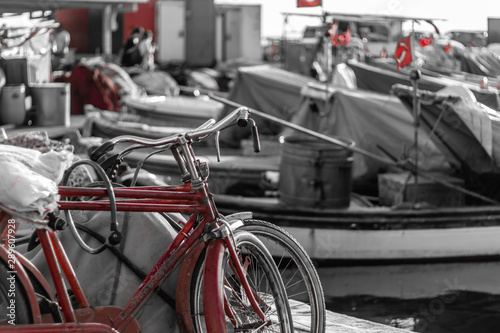 a black and white shoot from a fisherman bay - there is a red bicycle and turkish flags