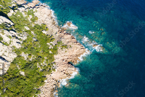 View from above  stunning aerial view of a green rocky coast bathed by a beautiful turquoise sea. Costa Smeralda  Emerald Coast  Sardinia  Italy.
