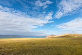 plateau meadow and lake against a blue sky