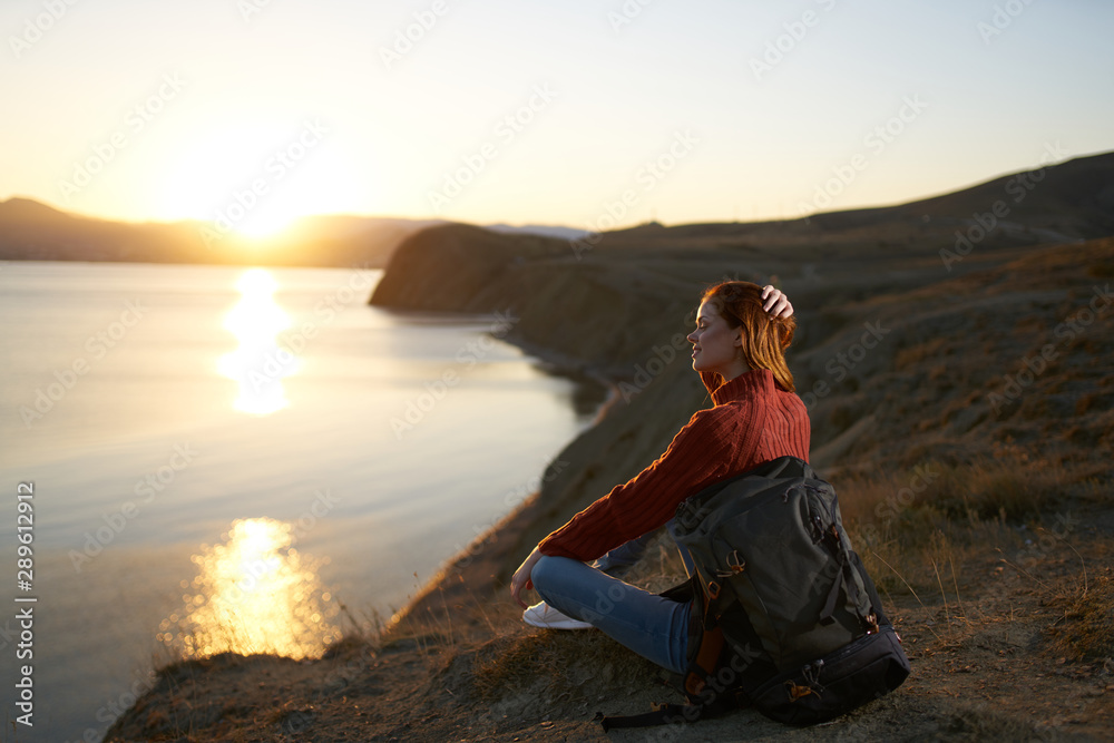 woman meditating on the beach at sunset