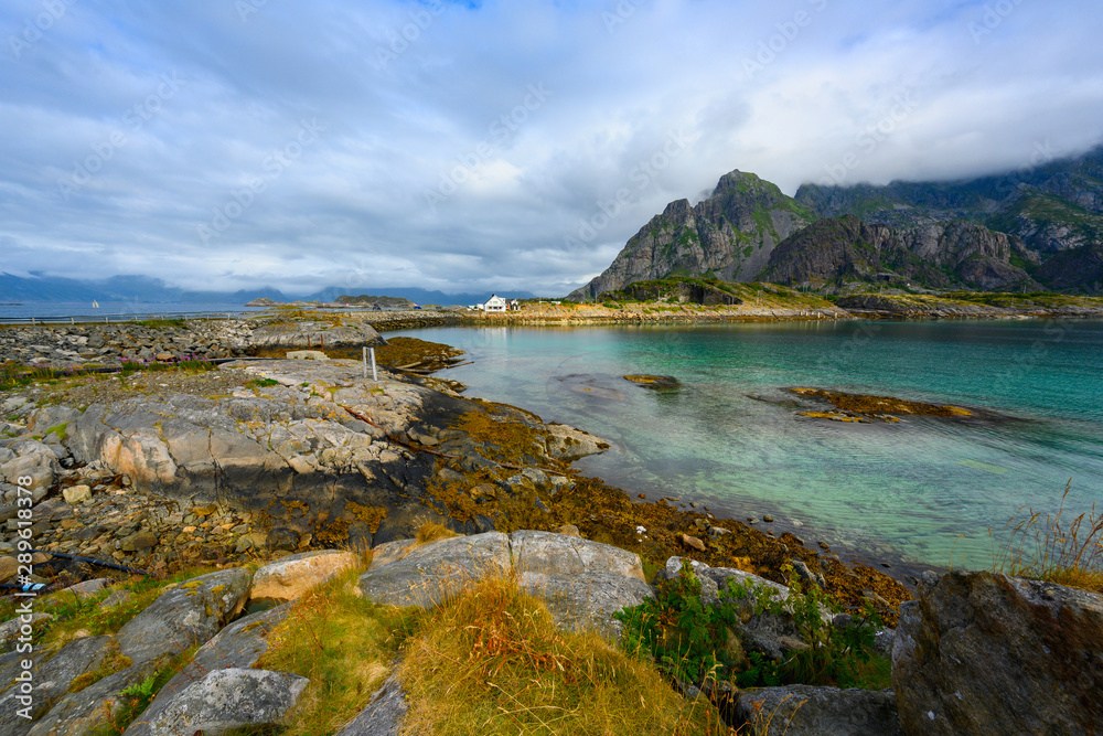 Viewpoint close to Henningsvaer, mountains, sea and rocks during the cloudy season in summer at the Lofoten Islands in Henningsvær, northern Norway