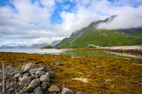 panoramic view at Gimsoystraumen Barstrand, Norway. The mountains and the blue sky during the day by the sea overlook the beautiful bridge. photo