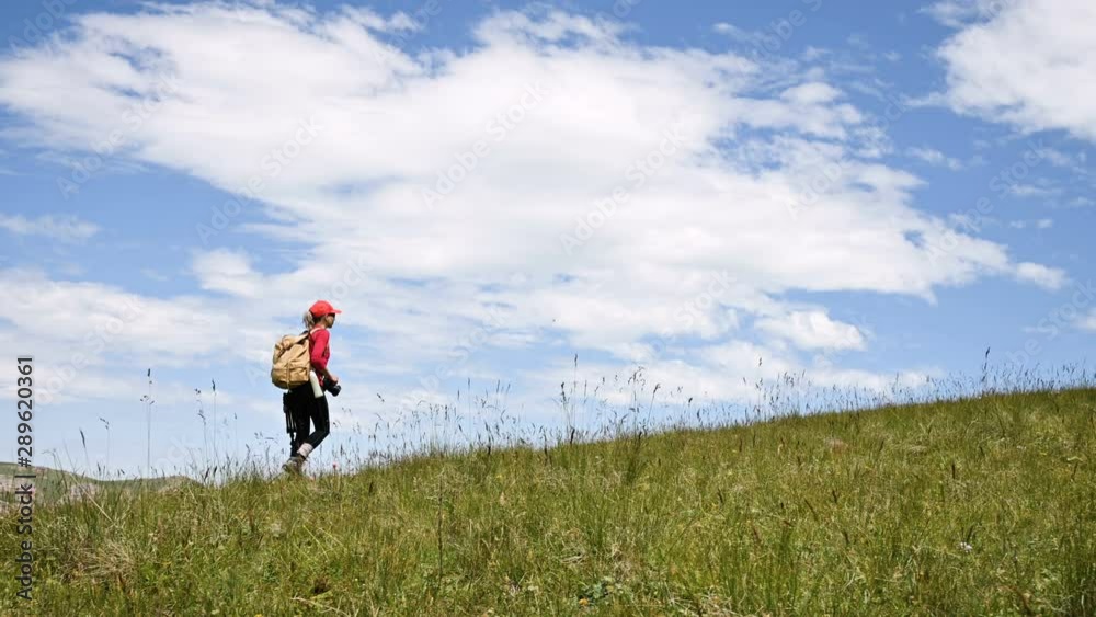 Girl photographer goes up the hill uphill against the backdrop of cliffs of a plateau and the sky with clouds. Concept photo tours for landscape photographers Girl photographer goes up the hill uphill against the backdrop of cliffs of a plateau and the sky with clouds. Concept photo tours for landscape photographers