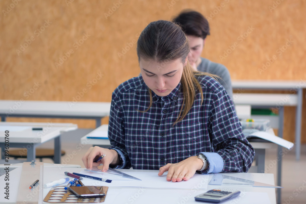 Pretty female university architecture student working on practice lessons. Looking for solution during class. Pretty female university architecture student working on practice lessons. Looking for solution during class.