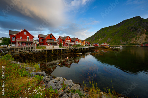 Beautiful waterfront house reflecting the water Evening and twilight sky at ballstad city, lofoten island in northern Norway. Rorbuer is the traditional home of Norwegian fishermen. © Lowpower