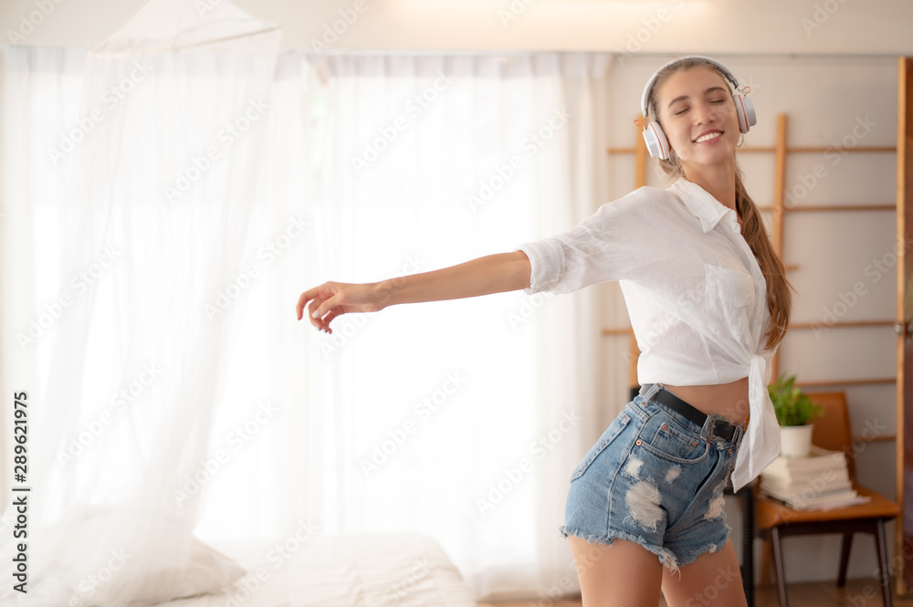 Girl listening to music through headphones and dancing to the beat.