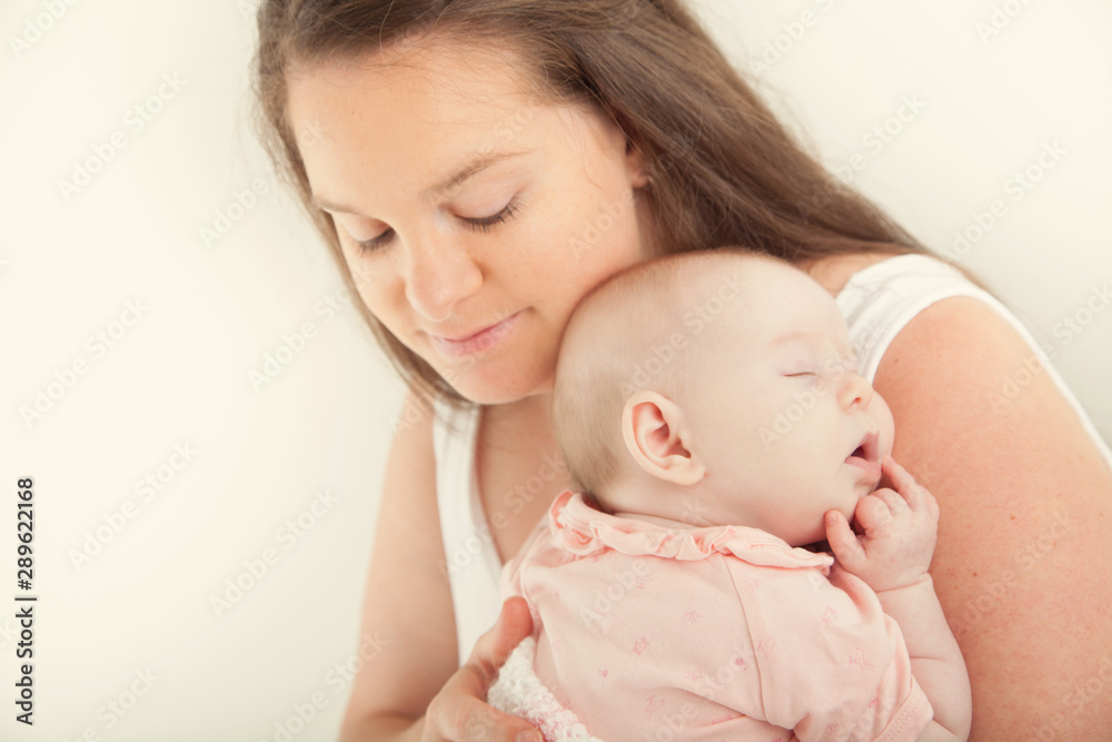 New mother shooshing baby to sleep on shoulder New mother shooshing baby to sleep on shoulder