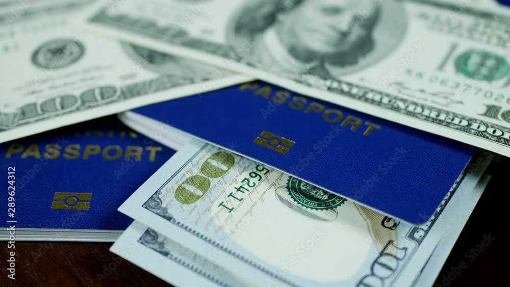 Dollar bills and blue ID passport on wooden background. Spend your vacation abroad. Visa opened concept Dollar bills and blue ID passport on wooden background. Spend your vacation abroad. Visa opened concept