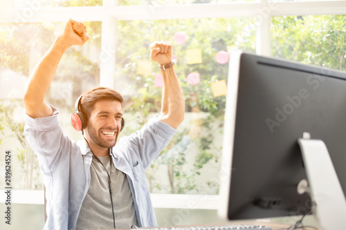 Tableau sur toile Happy man completed task and triumphing with raised hands and screaming