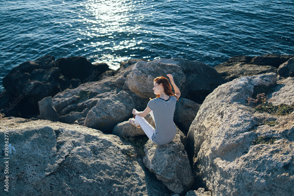 man sitting on a rock and looking at the sea man sitting on a rock and looking at the sea