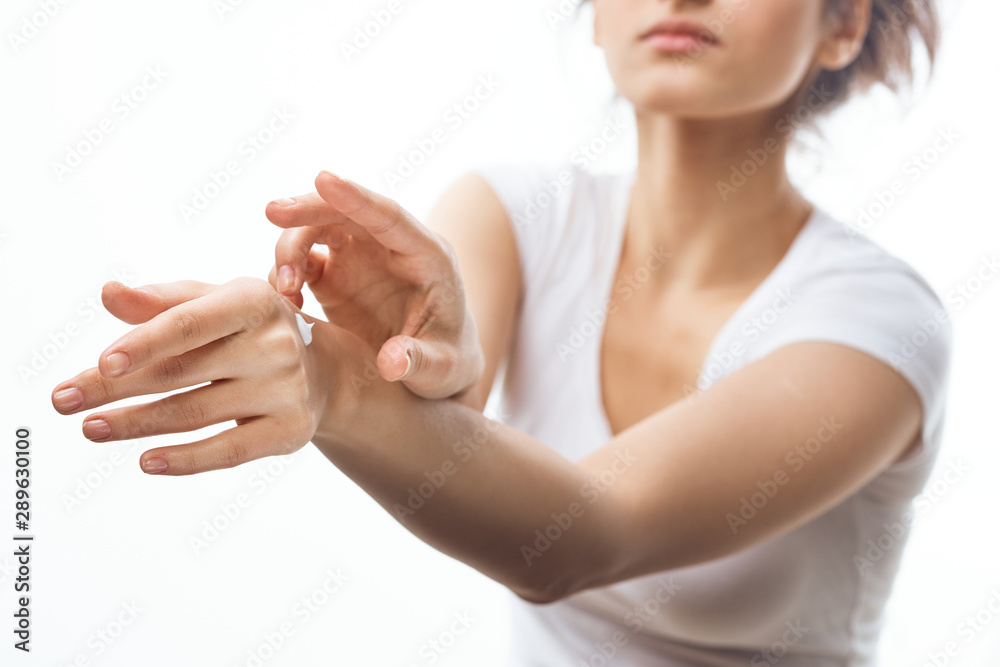 young woman applying cream on her face young woman applying cream on her face