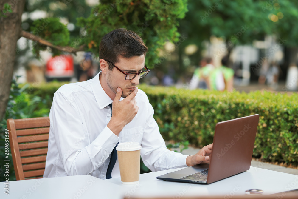 businessman working on his laptop in park businessman working on his laptop in park