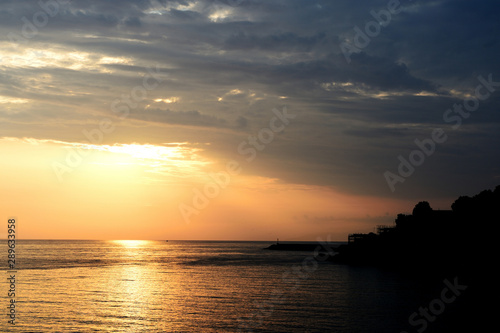 Magnificent sunrise over the sea and beautiful cloudscape on the coast of Sicily. Cefalu, Italy