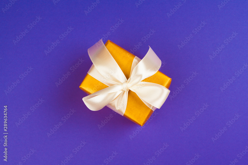 Gift box on purple background top view