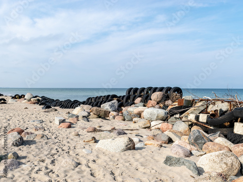 view of the sandy beach by the Baltic Sea. Seashore with old car tires and concrete, human waste, Curonian Spit, Russia