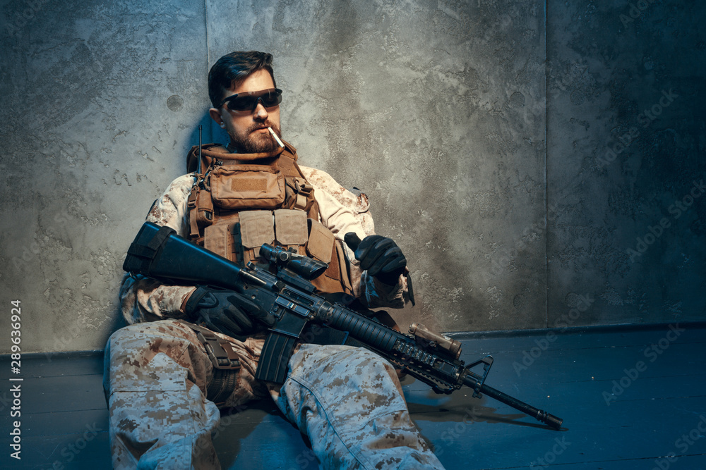 Fototapeta premium American private military contractor holding rifle. Image on a dark background