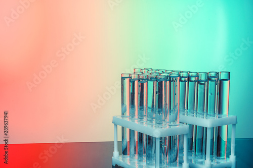 Row of test tubes with liquids on blue and green toned background