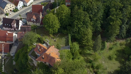 Aerial view of the village Betzenstein in Germany  on a sunny day in summer. Pan to the right above the hills of the village. photo