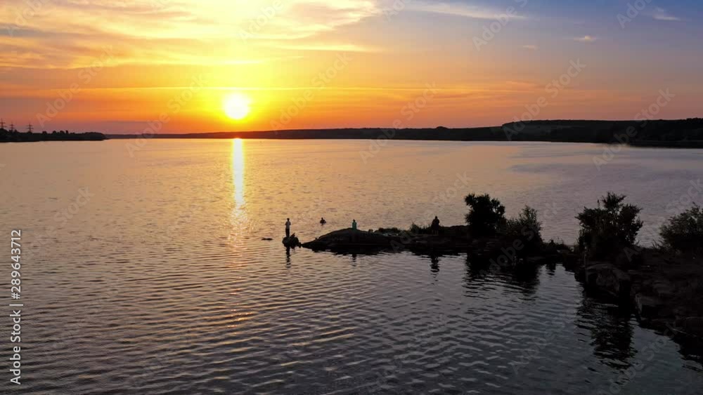 Atmospheric view of sunset. Reflection of sunset over river at evening Atmospheric view of sunset. Reflection of sunset over river at evening