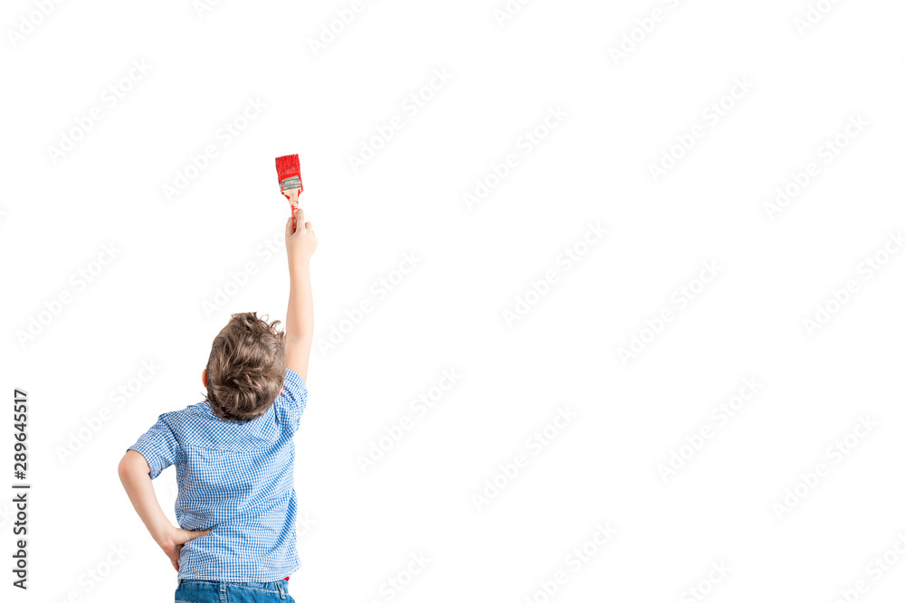 Boy paints a molar brush with a red paint on a white wall. Boy paints a molar brush with a red paint on a white wall.