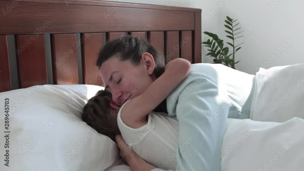 Mother and child hugging in bed in the mourning Mother and child hugging in bed in the mourning