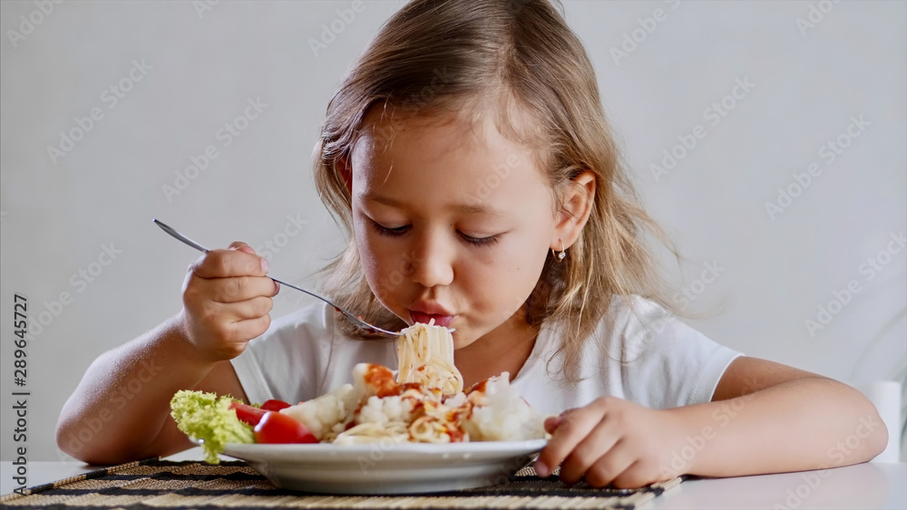 A little child girl is eating spaghetti at home A little child girl is eating spaghetti at home