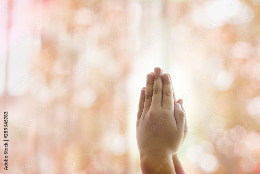 The girl is praying for wishes, the background image is a soft pink bokeh for copy space. The girl is praying for wishes, the background image is a soft pink bokeh for copy space.