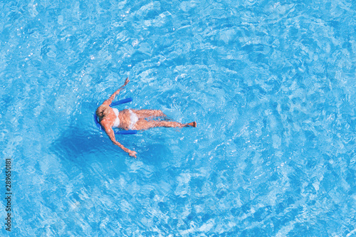 Woman in an outdoor pool, top view.