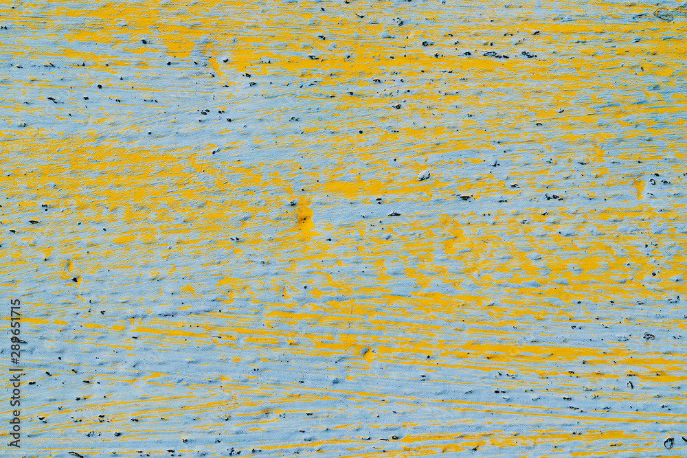 Surface painted blue with yellow paint strokes. Rough texture with different colors. Bright background for text or design Surface painted blue with yellow paint strokes. Rough texture with different colors. Bright background for text or design