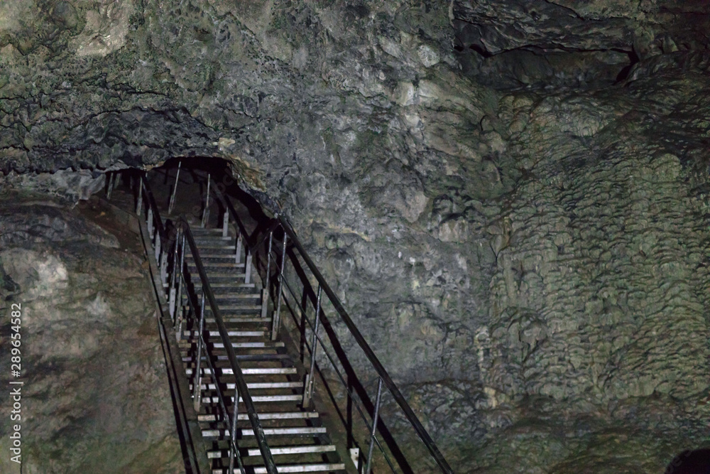 Underground cave equipped for visits. metal staircase in the cave going deep