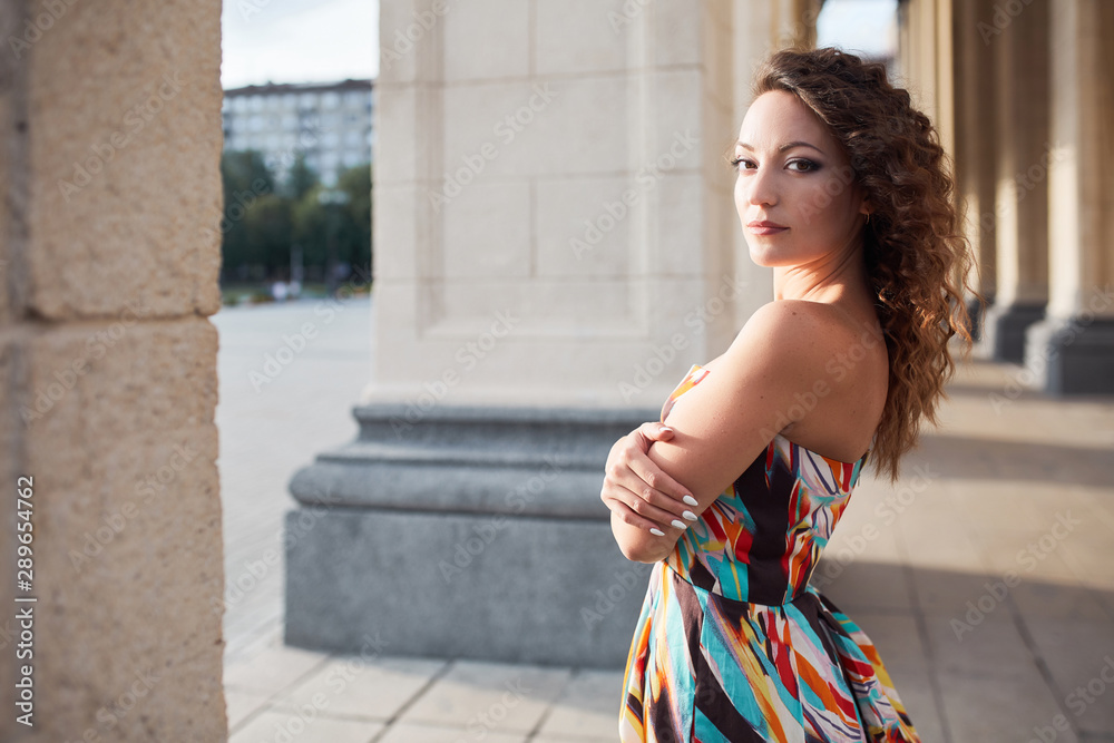 Beautiful brunette girl with hairstyle and make-up walks in the autumn summer park and smiles laughing Beautiful brunette girl with hairstyle and make-up walks in the autumn summer park and smiles laughing