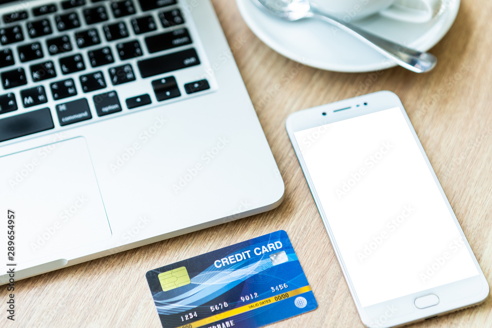 Credit card of laptop computer,smartphone and coffee cup on wooden background, Online banking Concept Credit card of laptop computer,smartphone and coffee cup on wooden background, Online banking Concept