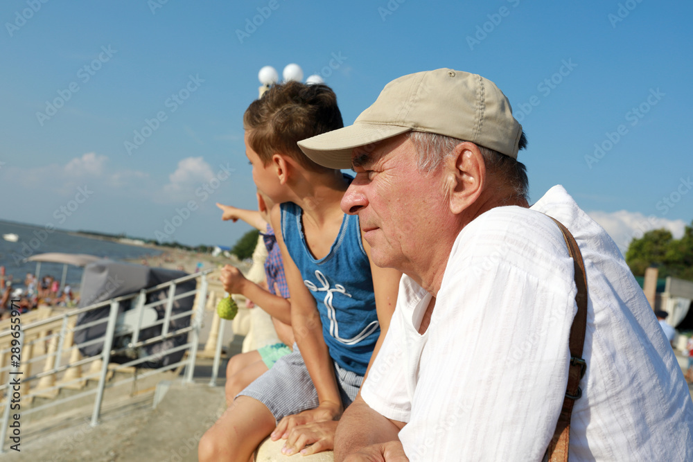 Grandfather and grandchildren look at sea
