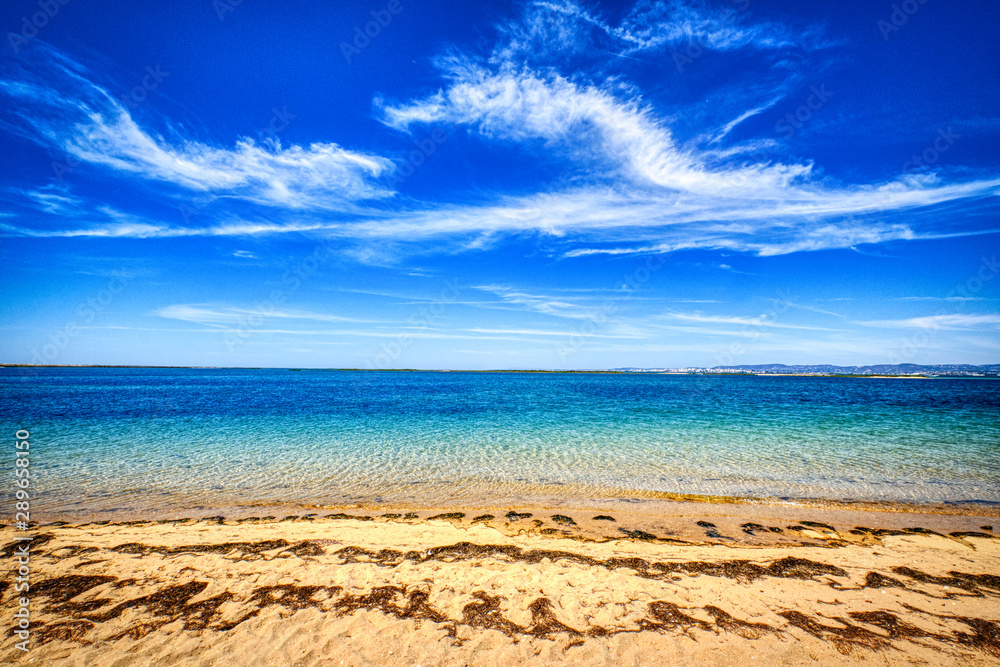 Beach with yellow sand, blue water and sky Beach with yellow sand, blue water and sky